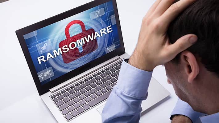 Businessman Looking At Laptop With Ramsomware Word On The Screen